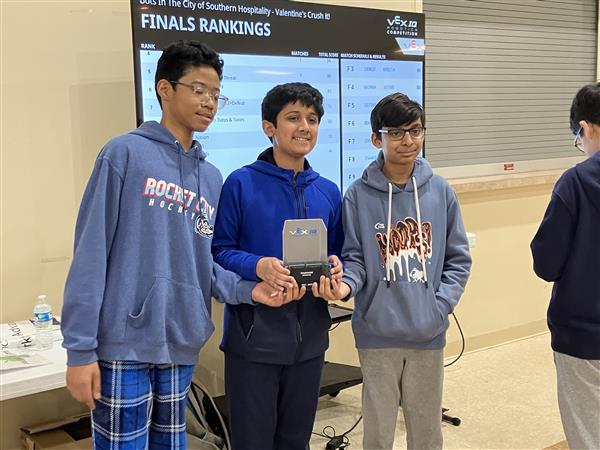 Students pose with a trophy.